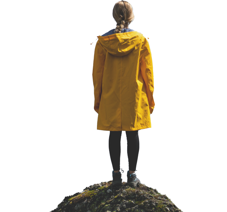 黄色いレインコートを着た女性人が山の頂上に立ち、晴れた日の山々と雲の景色を眺めている
